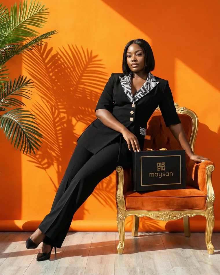 Photographie de mode créée à l'ACIA : femme en tailleur noir sur fond orange